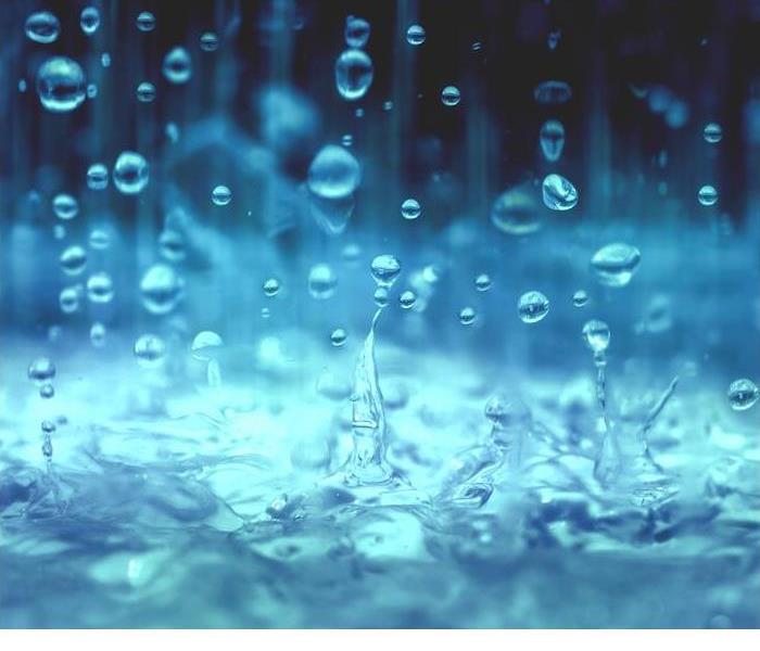 bright blue rain splashing into a pool of water